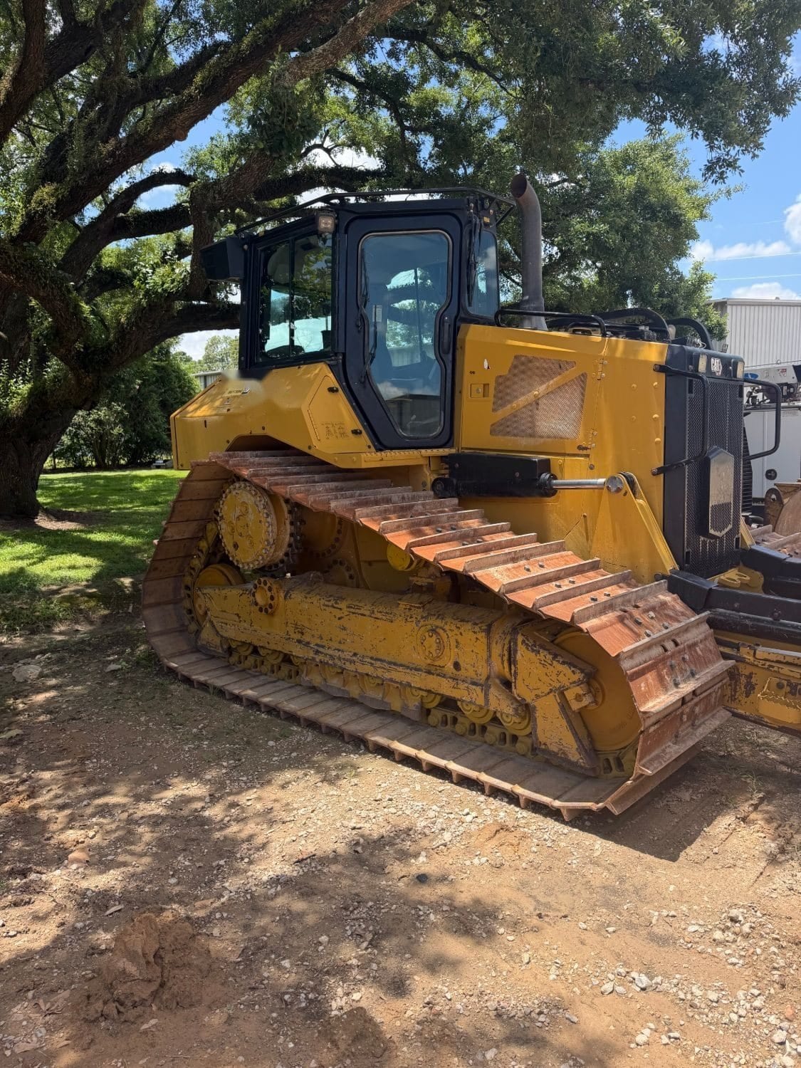 Cat D5 dozer parked under an oak tree at the Arch Machinery yard in Cypress